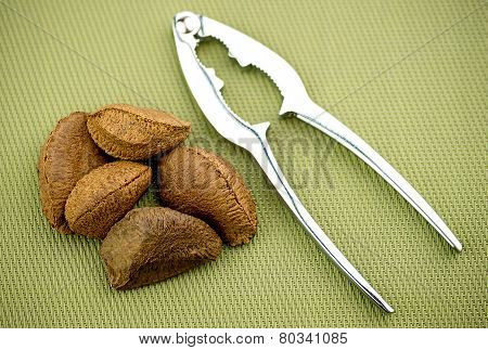 Brazil Nuts With Nut Cracker On Textured Background
