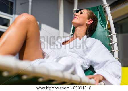 Woman realxing on lounger in wellness spa