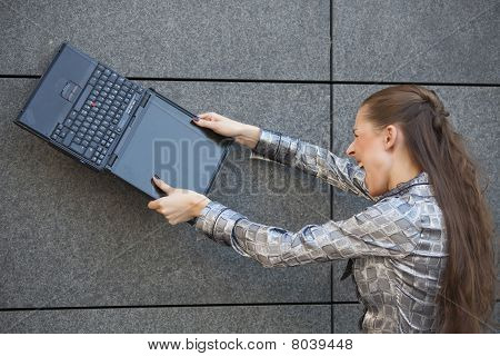 Frau vernichtende Laptop gegen Wand