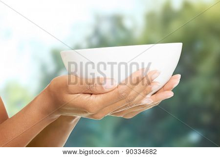 Beautiful woman's hands holding a bowl.