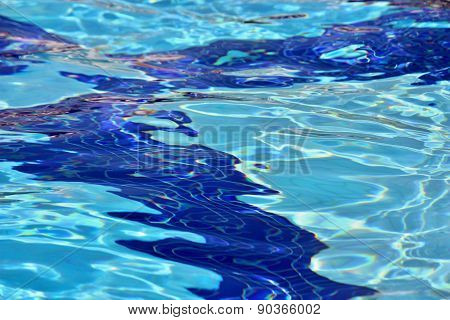 Swimming pool water surface with sparkling light reflections