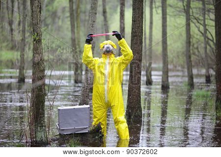 professional in protective coveralls with mini lab in contaminated environment