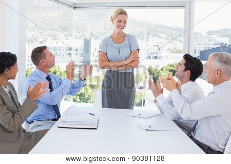 Business team applauding their colleague in the office