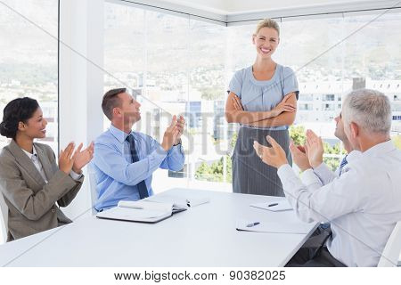Business team applauding their colleague in the office