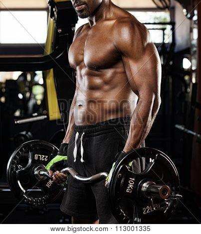 Strong bodybuilder with six pack, perfect abs, shoulders, biceps, triceps and chest