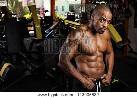 Young adult bodybuilder doing weight lifting in gym.