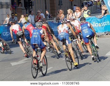 Rear View Of Large Group Of Male Cycling Triathlon Competitors