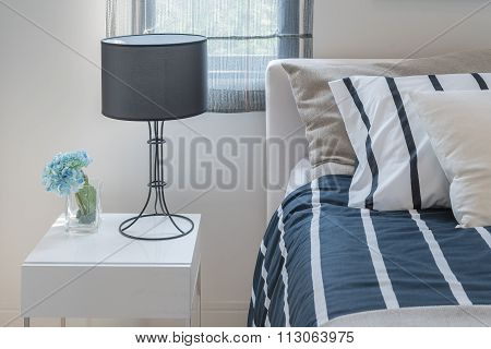 Modern Black Lamp With Glass Of Plant On White Wooden Table