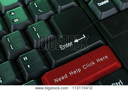 Close-up of laptop keyboard with color button and text Need help click here
