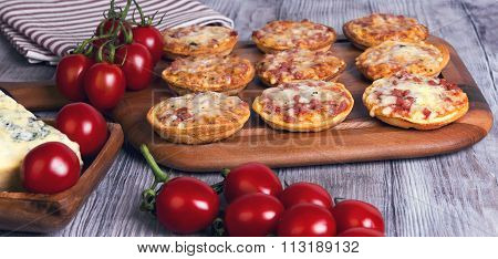 Mini Pizzas On A Wooden Table