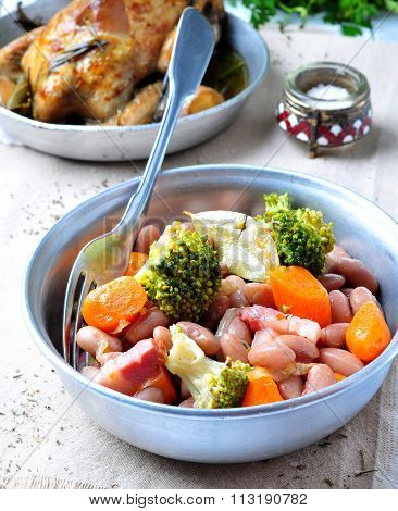 roast pigeon with Cassoulet beans, onions, bacon, carrots, broccoli, rosemary and parsley
