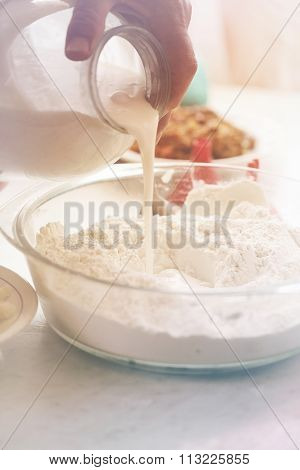 Pour sour milk into flour