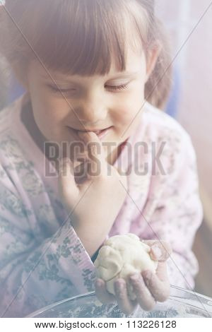 girl licks a finger dough