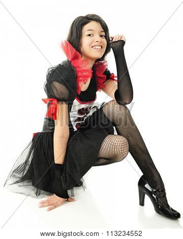 A beautiful young teen dressed in her Valentine's Day outfit, resting on her haunches.  On a white background.