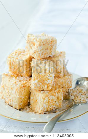 Cubes of marshmallow coated with roasted coconut bits, dessert treat bite size as a tea snack