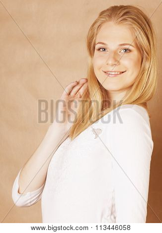 young cool blong teenage girl messed with her hair smiling close up