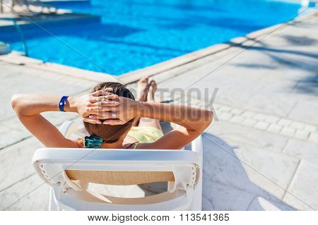 Woman Chaise Longue On The Background Of The Pool At The Hotel