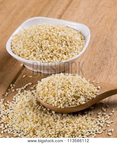 sesame seeds with wooden spoon on white background