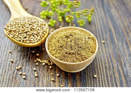 Coriander in bowl and spoon on dark board