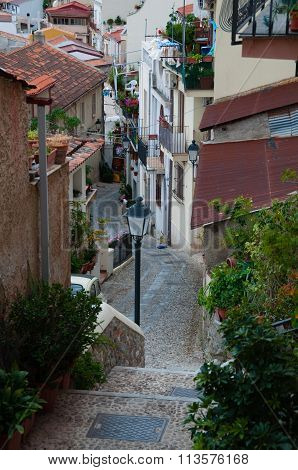Narrow street and stairs between cute italian houses in old town of Scilla
