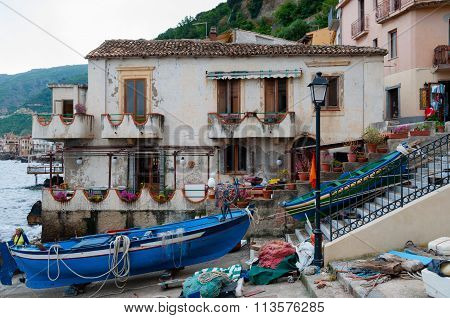 Blue and green boat in front of a house in the small italian town Scilla