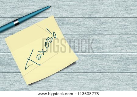 Taxes Sticky Note And Pen Lying On Desk