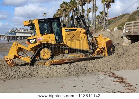 San Clemente CA Jan. 7 2016: A bulldozer pushes sand back against a retaining wall in an attempt to repair damage caused by the El Nino of 2016 which caused extensive damage around southern california