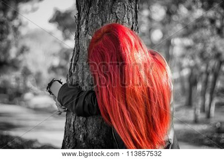 Red haired girl hugging a tree - Black and white photo with coloured hair