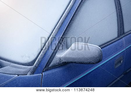 Car window and side mirror covered with ice in the morning