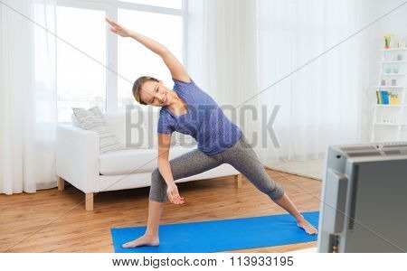 woman making yoga bikram triangle pose on mat