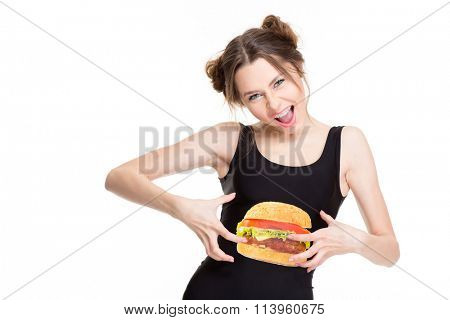 Playful shouting young woman in black top with hamburger print joking and touching her belly isolated over white background