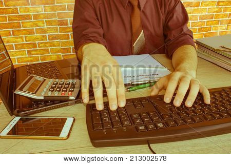 Business man doing finances on calculate analysis working with financial results Financial accounting sales forecast graph. Businessman Calculating Invoices Using Calculator - Retro color