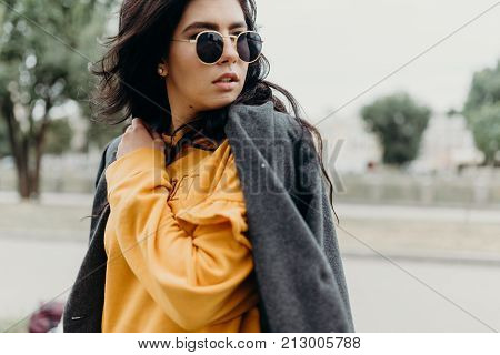 Portrait Of Stylish Modern Young Curly Woman In Coat Sunglasses