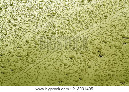 Rain Drops On Yellow Color Metal Car Surface.
