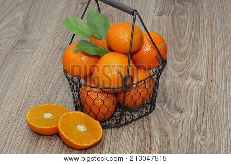 Clementines in a basket on a wooden table