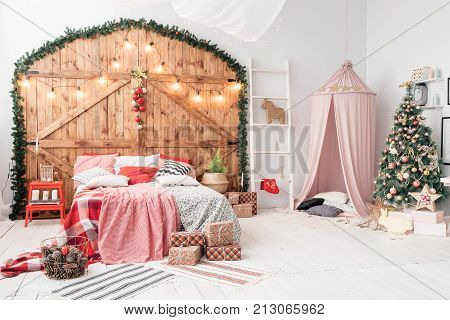 Xmas in morning bedroom. Double bed In christmas Interior on wood wall background.