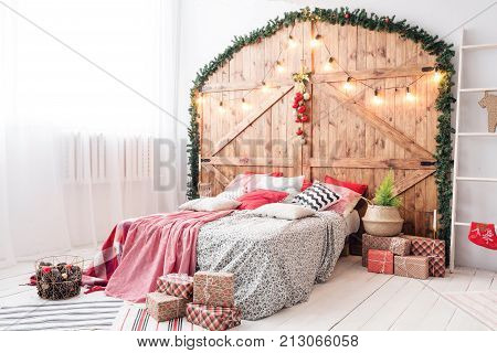 Xmas in morning bedroom. Double bed In christmas Interior on wood wall background.