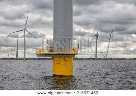 Construction site offshore windfarm near Dutch coast with cloudy sky. This park in the lake IJssselmeer near Urk is the biggest windfarm of the Netherlands
