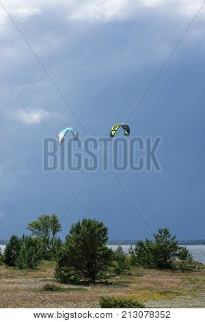 A kite surfer rides on the sea. Kites in the sky. Kite Boarding extreme sport on Mohni small island in Estonia Europe.