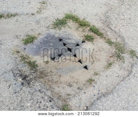 The Drain Hatch, Amid The Asphalt Hatch With Holes.