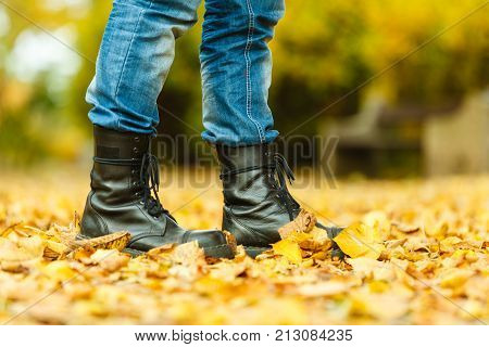 Nature outdoor foliage relax concept. Man in black boots. Male in leather footwear jeans trousers standing outside.