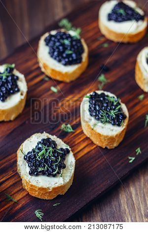 Appetizer for christmas table - black caviar on the pieces of bread