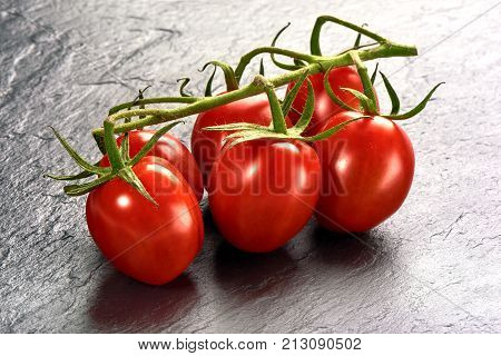 Ripe Fresh Cherry Tomatoes On Branch On Stone Plate