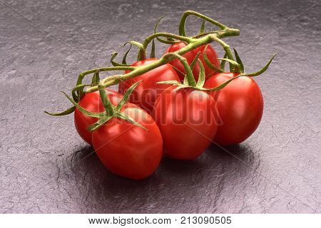 Ripe Fresh Cherry Tomatoes On Branch On Stone Plate