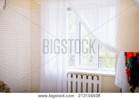 Tulle curtains on the window. An elegant old window with white curtains. Concept interior, cozy home.