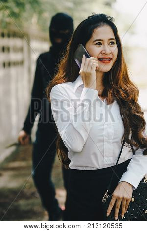 Robber will threat a office girl with a knife on the way she walking home. She using smart phones and did not beware the thief who sneaks behind.