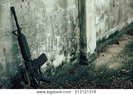 M4A1 (AR-15) M-16 assault rifle gun for the American military is placed beside the old wall.