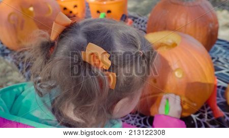 Little girl carwing pumpking in the park.