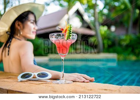 Women wearing bikini or swimware suits swimming pool Drinking water melon smoothie at the resort town of Pattaya in Thailand.