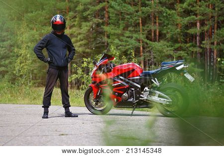 Krasnoyarsk, Russia - August 09, 2017: A Motorcyclist Wearing A Helmet With A Black Visor And Red Sp